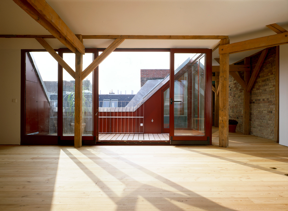 Ausbau eines Dachgeschossrohlings in Berlin für eine Baugruppe, Wohnbereich, Dachterrasse, gesandstrahlte Giebelwand und Dachstuhl