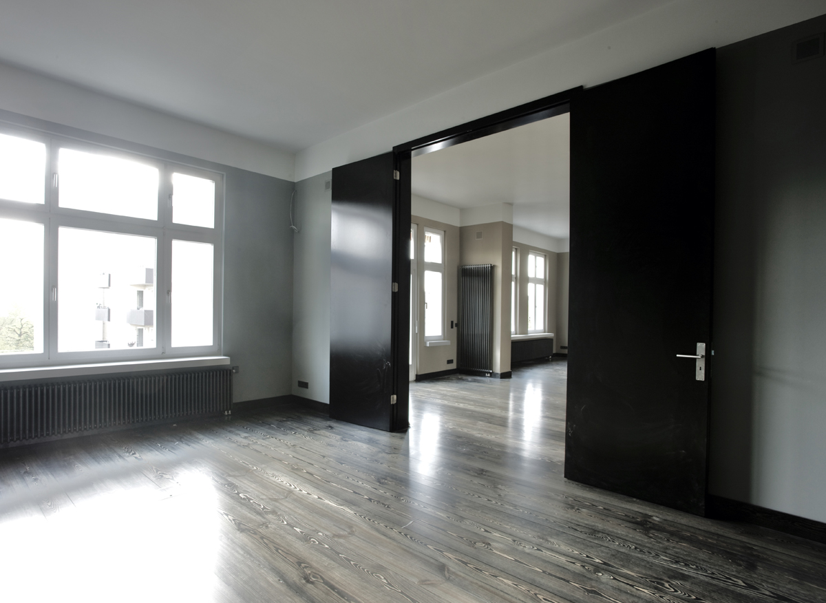 Ausbau einer Gründerzeitwohnung in Berlin, offener Wohnbereich, fliessender Raum, massive Kiefernholzdielen, raumhohe Doppelflügeltür
