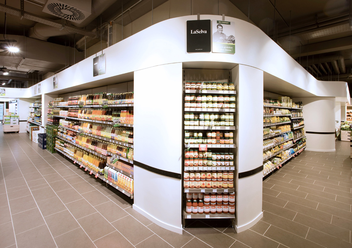 Konzept für den Ausbau der Bio Company Filialen, Präsentation in Wandregalen, Nischen in umlaufender, geschwungener, weisser Baustruktur