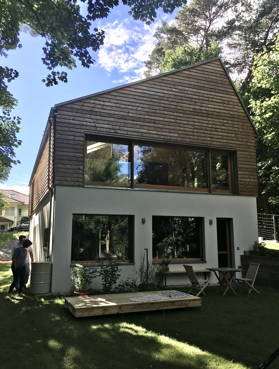 Ökologisches Einfamilienhaus in Brandenburg, Gartenseite mit Giebelverkleidung aus unbehandelten Lärchenholzbohlen