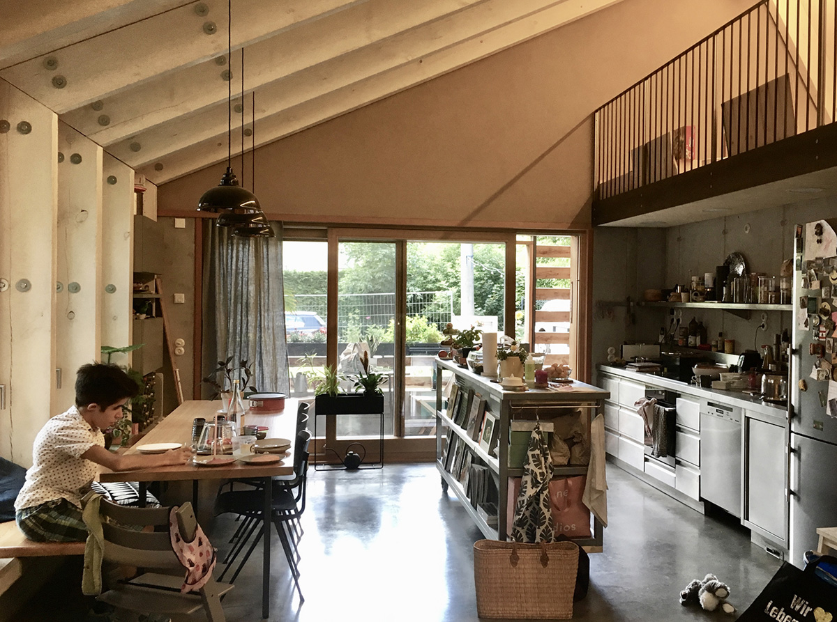 Ökologisches Einfamilienhaus in Brandenburg, offener Wohnbereich mit Küche und Essplatz, Galerie, Holzbinder, integrierte Möblierung