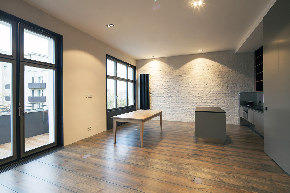 Wohnungsausbau Berlin, Schöneberg als Loft, Wohnbereich mit geschlemmten Wänden und Fussboden aus Märkischen Kieferndielen von Holz-lebt